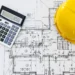 close up of house blueprints with yellow helmet 2023 11 27 04 49 46 utc scaled 1