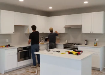 Kitchen remodeling scene residential kitchen under renovation workers installing cabinets construction in progress tools and materials partially completed kitchen new countertops being installed modern kit