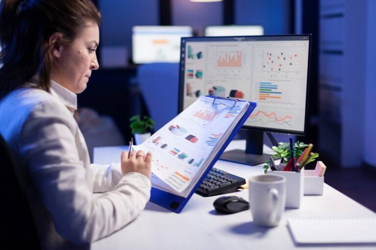 freelancer woman comparing graphics from clipboard with grafics from computer business office1 2