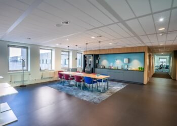 interior kitchen area modern office with long wooden table chairs
