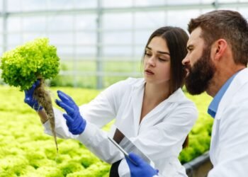 woman man laboratory robes examine carefully plants greenhouse 2