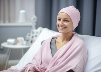 woman with pink towel wrapped around her head simple beauty routine home happy cancer patient smiling woman after chemotherapy treatment hospital oncology department ai generated 2